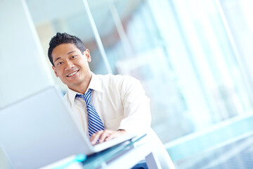 Fototapeta premium Portrait, business and man on laptop in office for stock market, trading research and financial website. Happy, trader and online report for investment deal, banking feedback and exchange information