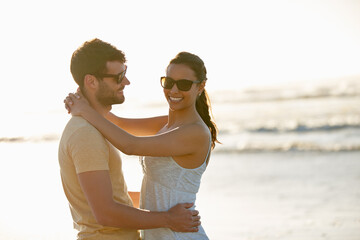 Beach, portrait and couple embrace with sunset, space and holiday in nature for outdoor adventure. Ocean, man and woman hug on romantic island vacation for bonding, support or fun travel on honeymoon