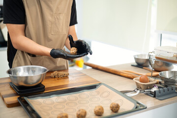 Young entrepreneur preparing homemade chocolate chip cookies in modern kitchen
