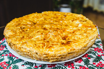 Homemade prebranac, Serbian cheese burek on a festive plate. Freshly baked, warm atmosphere, close-up shot, slightly tilted angle, home setting, traditional pastry, inviting concept, holiday 