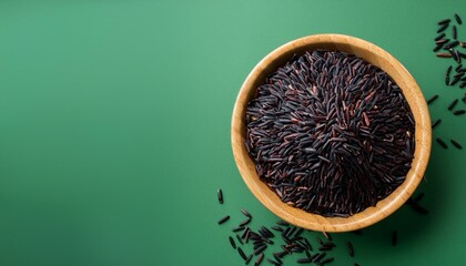 Fresh healthy wild black rice on green background