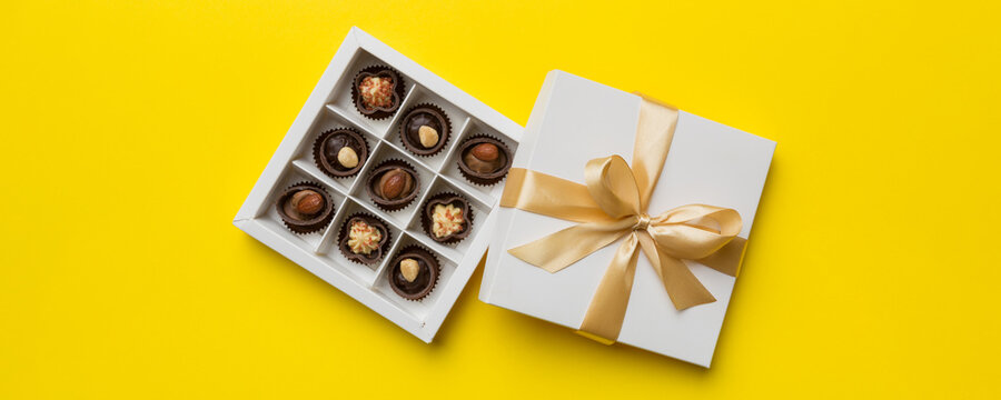 White box with chocolates candies and golden tape. top view with copy space