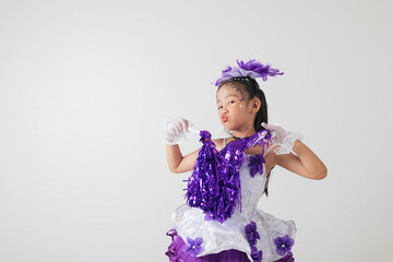 Youthful cheerleader in purple and white outfit holding pom-poms, smiling brightly. Studio image on a clean white backdrop. cheerleader kid