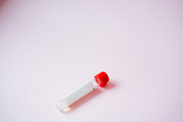 A strikingly bold redcapped test tube is placed elegantly upon a vibrant pink surface, resulting in a captivating and visually stimulating contrast within the laboratory setting