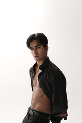 Obraz premium Handsome young man looking at the camera posing over white background. Vertical.