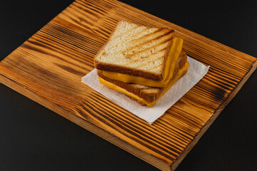 Delicious grilled cheese sandwich on wooden board ready to enjoy