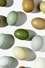 Natural eggs repeat pattern, green brown blue colored Chicken egg with shadow at sunlight, creative food layout. Minimal Easter holiday concept, top view still life, trend patterns, flat lay
