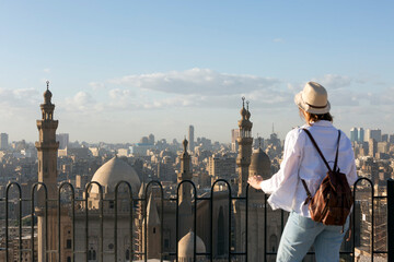 Young woman tourist looking at the Mosque and Madrasa of Sultan Hasan in Cairo, Egypt