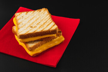 Delicious grilled cheese sandwich stacked on a vibrant red napkin