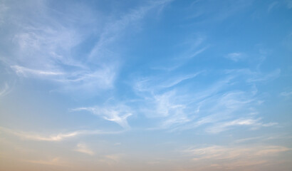 Obraz premium the sky is clear with fiuffy white clouds and beautiful orange light.