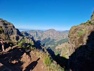 Fototapeta premium Rugged landscape of Madeira, featuring deep valleys and steep cliffs, hike from pico do arieiro to pico ruivo