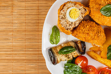 Delicious golden fried stuffed food with salad on a bamboo mat