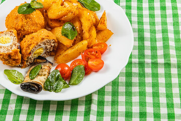 Delicious plate of breaded meat with potatoes and fresh vegetables