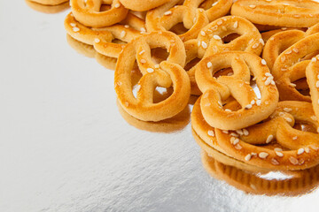 Deliciously baked pretzels with sesame seeds on a reflective surface