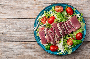 Salad with raw tuna , sesame and cherry tomatoes photography . Top view