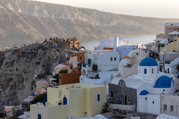 Whitewashed buildings and the ruins of Castle of Agios Nikolaos on the edge of the caldera cliff, Oia village, Santorini, Greece