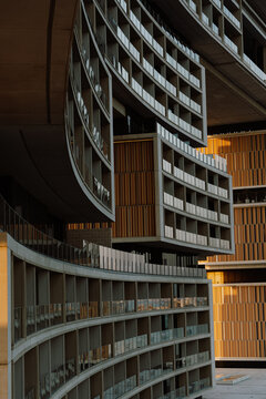 A close up architectural shot of a modern luxury hotel with curved balconies and geometric design. The intricate facade and lighting highlight the elegance of contemporary architectecture
