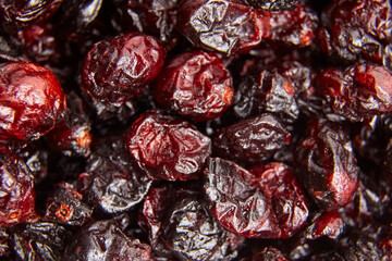 Detailed close-up of dried cranberries with rich red hues, wrinkled texture, and glossy finish, perfect for food, snack, or nutrition visuals