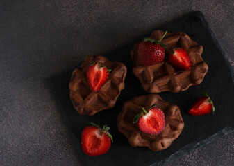 dessert pastry chocolate waffles with strawberries on a dark background