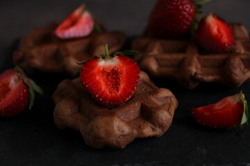 dessert pastry chocolate waffles with strawberries on a dark background