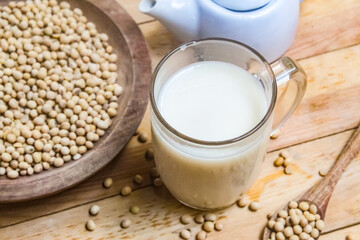 a glass of soy milk with soy beans on the table