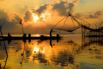 Golden Hour Serenity: Traditional Thai fishing nets silhouetted against a vibrant sunset sky. Perfect for your next travel or nature-themed project.
