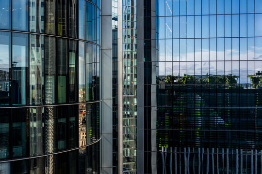 Cityscape reflections on sleek glass surfaces of London&rsquo;s high-rise buildings.