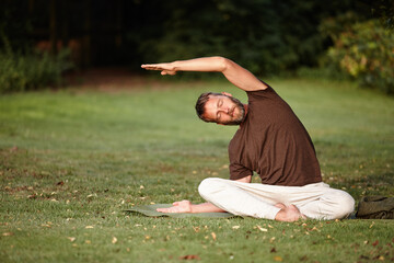 Yoga, stretching and relax with man in nature for parighasana pose, peace and exercise balance. Wellness, workout and flexible with person on lawn of spiritual retreat for mindfulness, calm and zen
