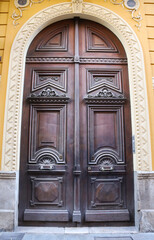 Building entrance with carved stone details and old wooden door