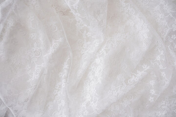 White lace fabric draped elegantly on a flat surface for crafting