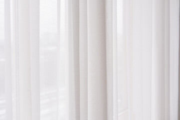 Soft white curtains gently filtering light in bright indoor space
