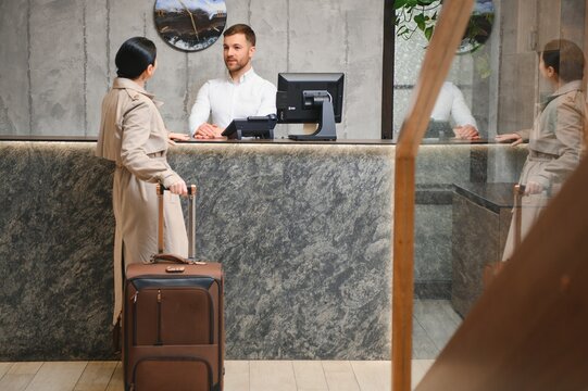 Female guests come with bags and suitcases to the hotel reception in the lobby