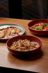 A variety of delicious dishes, including potato pancakes with bacon and mushrooms, stir-fried udon noodles with chicken, and fried rice with shrimp.