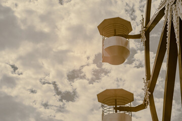 Infrared photography, two structures that appear to be part of a ferris wheel against a cloudy sky
