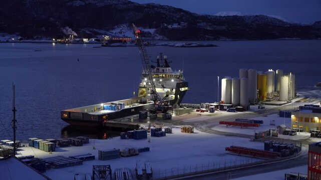 Mobile crane unloads containers from the offshore supply vessel at Vestbase in Kristiansund, Norway