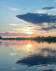 Beautiful sunset over a lake with a reflection of the sun on the water