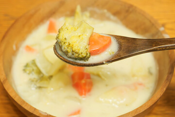 Trying to eat warm milk stew with a spoon