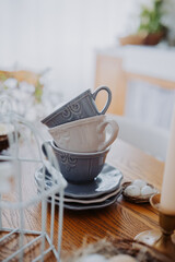 Stacked ceramic cups on a wooden table in a cozy living space
