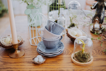 Stacked cups and nature-inspired decor on a wooden table for spring gathering
