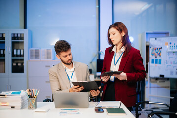 Female discussing new project with male colleague. Young woman talking with young man