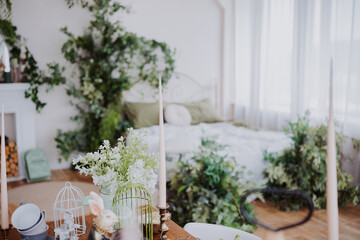 Cozy bedroom decorated with greenery and candles in soft natural light