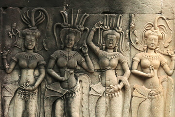 Four dancing apsaras carved onto a wall of the temple of Angkor Wat, Siem Reap, Cambodia