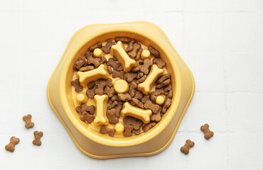 Dry dog food in slow feeder bowl preventing gulping