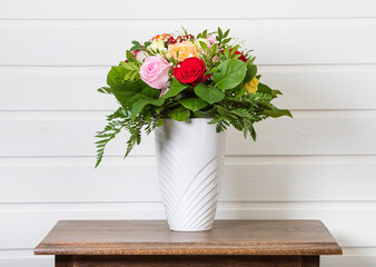 Bouquet with a variety of roses in a vase on a side table