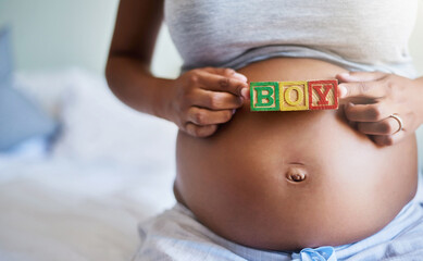 Hands, pregnant woman and blocks for gender reveal, boy and expect son in home bedroom. Stomach, pregnancy and future mom with words on body for love, prenatal care or baby announcement in maternity