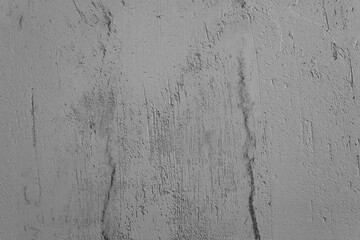 Textured gray wall with subtle patterns and scratches in natural light