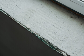 Cracked concrete surface near window showing weathering and wear