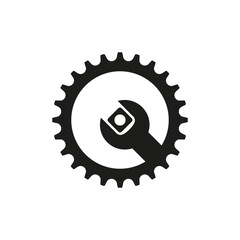 Spanner inside cogwheel. Bicycle sprocket and gear with wrench. Bike repair and servicing. Logo and gear icon. Isolated vector illustration on white background.