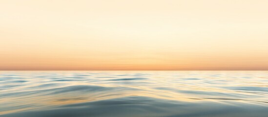 Fototapeta premium Serene seascape at sunset with soft pastel hues blending orange and blue, gentle waves reflecting light in the foreground and horizon.