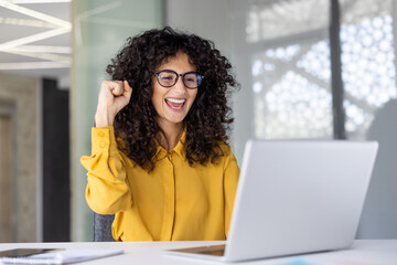 Successful joyful woman celebrating victory and successful achievement results. Businesswoman at...